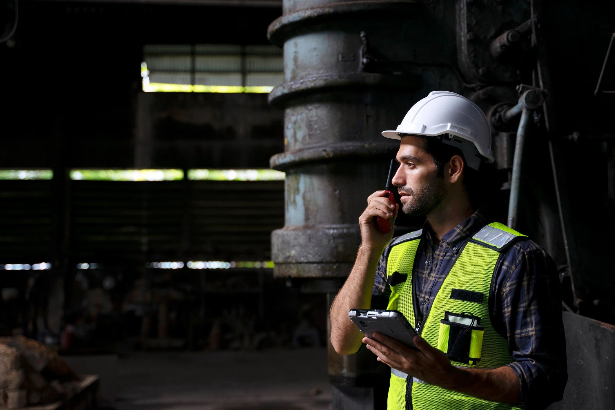 Industrial worker inspecting machinery in a factory environment